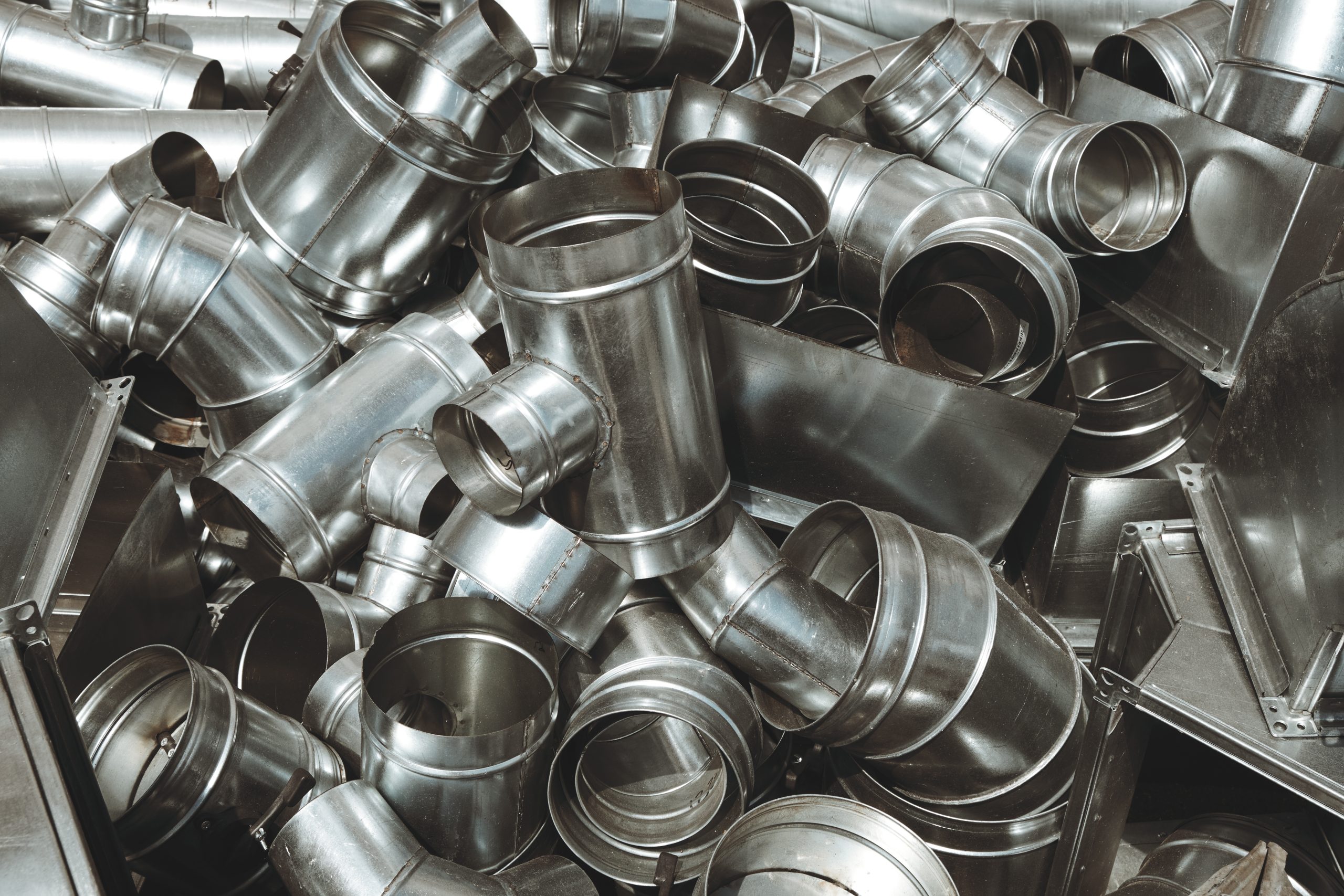 Pile of pipes and parts for duct systems. Industrial ventilation